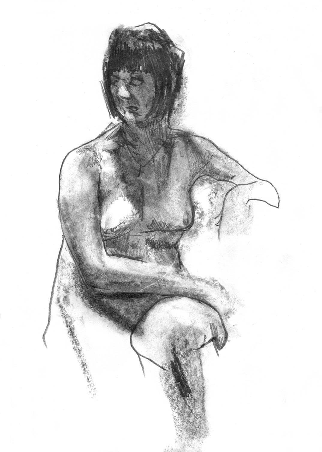 Female model seated with right arm crossing her body looking back to her right