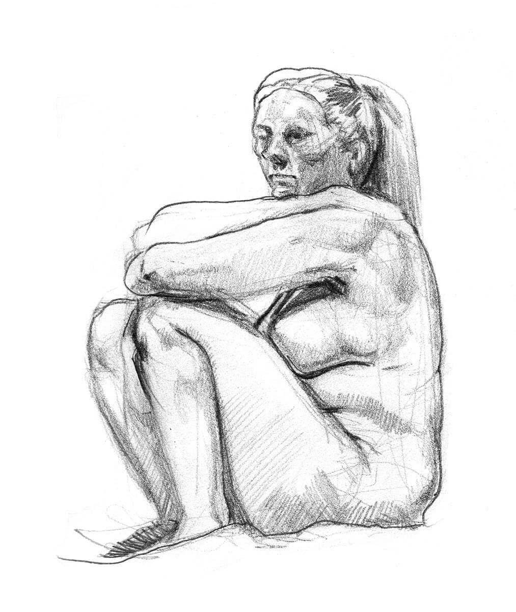 Seated female model with knees bent toward chest while amrs rest ontop of her knees